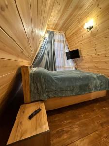 Cette chambre en bois comprend un petit lit et une table. dans l'établissement A.frame-house, à Tsaghkadzor