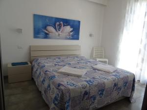1 dormitorio con 1 cama con una pintura en la pared en Casa Diamante en San Vito lo Capo