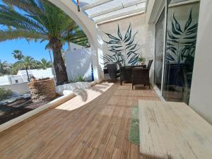 un patio con una mesa y una palmera en Palm Point, en Costa Calma