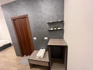 a room with a desk and a bed with a door at Caprios motel in Al Qasţal