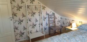 a bedroom with a bed with purple flowers on the wall at Slåta - The Dragon-valley cabin in Lyngdal