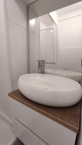 La salle de bains est pourvue d'un lavabo blanc et d'un miroir. dans l'établissement Apartman BARBARA, à Vinkovci