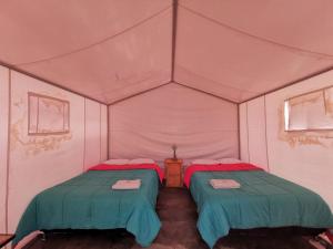 a room with two beds in a tent at Ecocamp Huacachina in Ica
