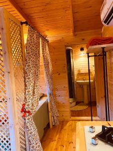 Habitación con cabina de madera con cortinas. en Gayb-i Bungalows by Naturelife - Free Access to Beach & Naturelife Spa, en Cıralı