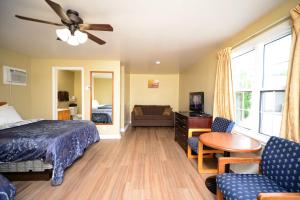 1 dormitorio con cama, mesa y sofá en Homeward Inns of Canada en Antigonish