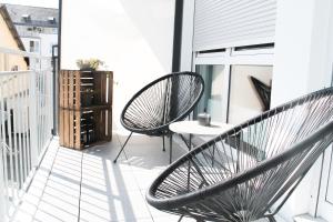 コブレンツにあるMarvel-Apartment - für Freunde & Familien, stadtnah, Parkplatz, E-Ladestation, Gitterbox für Fahrräder, Fitnessstudio, digitale Gästemappe mit Restaurant- und Unternehmenstippsのバルコニー(椅子2脚、テーブル付)