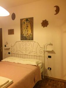 B&B MARILYN في رافينا: غرفة نوم بسرير أبيض مع صورة على الحائط