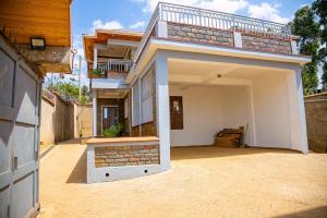 a house with an open garage with a balcony at MacCinray Villa Kisii in Kisii
