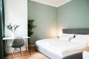 sypialnia z białym łóżkiem i krzesłem w obiekcie 50qm Apartment in Krefeld zentral gelegen mit hohen Decken - BEUYS Apartments - Krefeld w mieście Krefeld