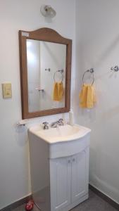 y baño con lavabo blanco y espejo. en Rincón Mágico en Trelew