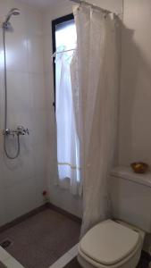 a bathroom with a white shower curtain and a toilet at Rincón Mágico in Trelew
