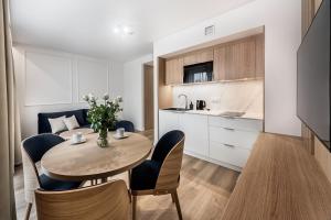 a kitchen and dining room with a table and chairs at Aurum Aparthotel - Nowe Apartamenty blisko Plaży - Neue Appartements in Strandnähe in Świnoujście