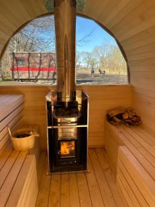 a woodburning stove in a sauna with a window at Bellinge House in Horreby