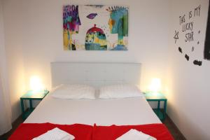 a bedroom with a white bed with two tables at Apartman Maria 1 in Rab