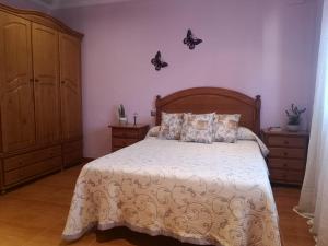 a bedroom with a large bed with a wooden headboard at murillavacacional in Moaña