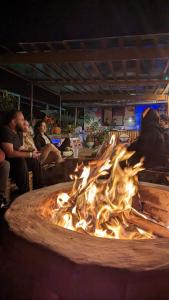 a fire pit with people sitting around it at night at Vibes Aurik in Quito
