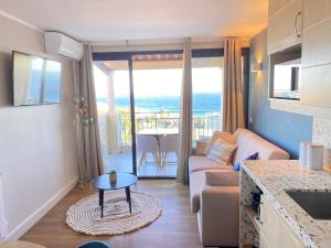 ein Wohnzimmer mit einem Sofa und einem Tisch in der Unterkunft Cannes - Appartement rénové avec vue mer imprenable in Cannes