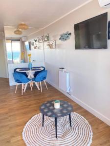 ein Wohnzimmer mit einem Tisch und blauen Stühlen in der Unterkunft Cannes - Appartement rénové avec vue mer imprenable in Cannes