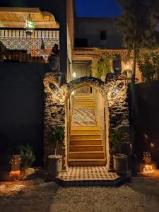 an entrance to a house at night with a gate at Riad Villa Dades in Boumalne