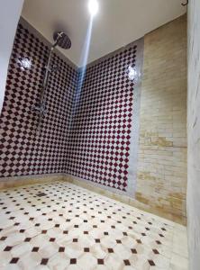 La salle de bains est pourvue d'une douche et de carrelage. dans l'établissement Riad Villa Dades, à Boumalne