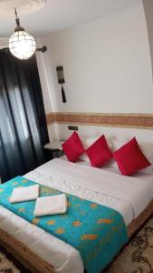 1 dormitorio con 1 cama grande con almohadas rojas en Riad Villa Dades, en Boumalne