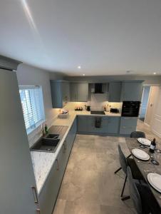 a kitchen with blue cabinets and a table with chairs at Harbour view apartment in Annalong