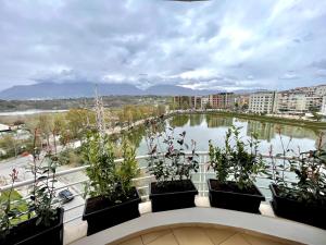 a balcony with plants and a view of a river at Queen’s Luxury Apartments Lake in Tirana