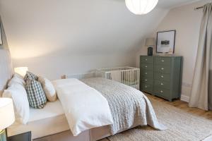 a bedroom with a white bed and a green dresser at Cosy family home in Strandhill in Sligo