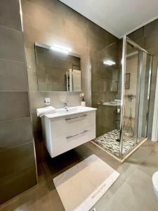 a bathroom with a sink and a shower at Queen’s Luxury Apartments Lake in Tirana