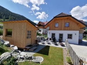 una casa con un patio con sillas delante en Ferienhaus Weißpriach, en Weisspriach