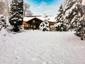 um pátio coberto de neve em frente a um edifício em Sielsko i Zacisznie em Ełk