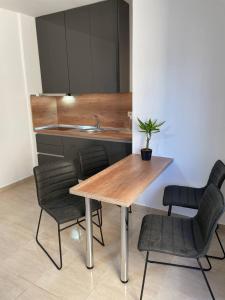 una cucina con tavolo, sedie e lavandino di High-Tech flat a Durrës