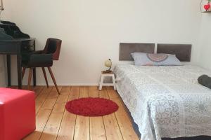 1 dormitorio con cama, piano y alfombra roja en Exklusive 3-Zimmer-Wohnung, 2 Ebenen, Messe, Zentrum, 67 m2 en Bremen