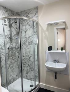 een badkamer met een douche en een wastafel bij The Vine Hotel Chapel st Leonards in Skegness