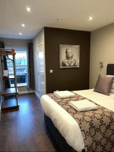 een slaapkamer met een groot bed met een foto aan de muur bij The Vine Hotel Chapel st Leonards in Skegness