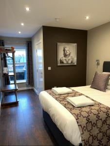 a bedroom with a large bed with a picture on the wall at The Vine Hotel Chapel st Leonards in Skegness +25 photos