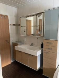 een badkamer met een wastafel en een spiegel bij Ferienwohnung Körber in Gößweinstein