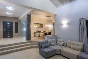 Saronic TopView Villa في غالاتاس: غرفة معيشة مع أريكة وطاولة
