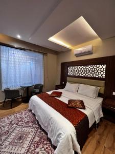 ein Schlafzimmer mit einem großen Bett und einem großen Fenster in der Unterkunft شاليهات وايت هافن - ابها in Chamis Muschait