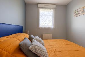 1 dormitorio con 1 cama grande de color naranja y ventana en LaConciergerieJonzac, Appartement Belles Des Champs, en Jonzac