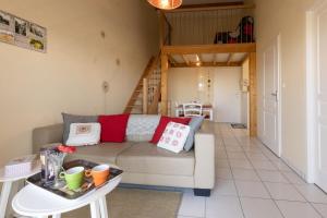 a living room with a couch and a table at Appartement 1 Chambre "Belle Des Champs" in Jonzac
