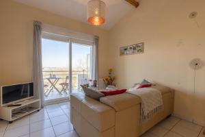 a living room with a couch and a television at Appartement 1 Chambre "Belle Des Champs" in Jonzac