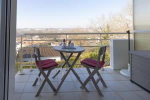 - Balcón con mesa y 2 sillas en LaConciergerieJonzac, Appartement Belles Des Champs, en Jonzac