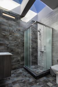 a bathroom with a glass shower and a sink at Saronic TopView Villa in Galatas