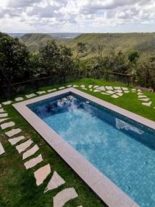 una piscina en medio de un césped con vistas en Roça Cult - Casa Baru, en Brasilia