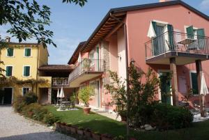 un bâtiment de couleur rose et jaune dans l'établissement Corte Valesana, à Lazise