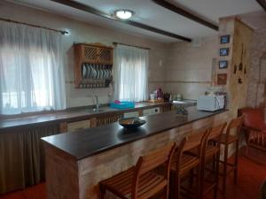 eine Küche mit einer Theke und einigen Stühlen in einem Zimmer in der Unterkunft Alojamiento Rural Mi Frasca in Almodóvar del Río