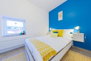 una camera con un grande letto con una parete blu di Casa AVA a Straja