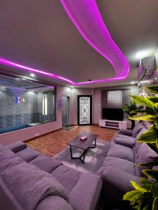 una sala de estar con luces moradas en el techo en شاليهات وايت هافن - ابها en Khamis Mushayt