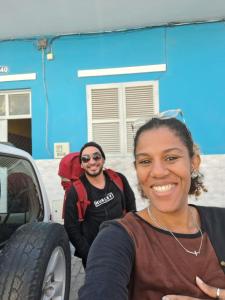 a man and a woman standing next to a truck at In The Heart Of Praia - Family B&B in Praia